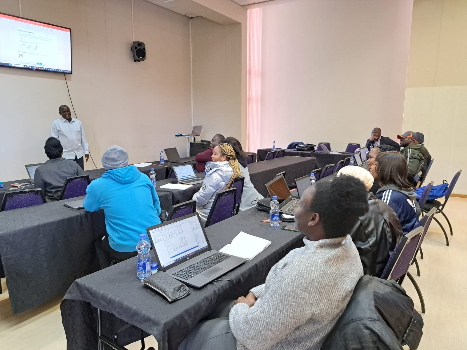 Participants suivant une session de formation en salle, ordinateurs portables ouverts